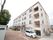 白色を基調とした４階建ての建物である。駐車場や駐輪スペースがある。階段の近くにゴミステーションがある。
