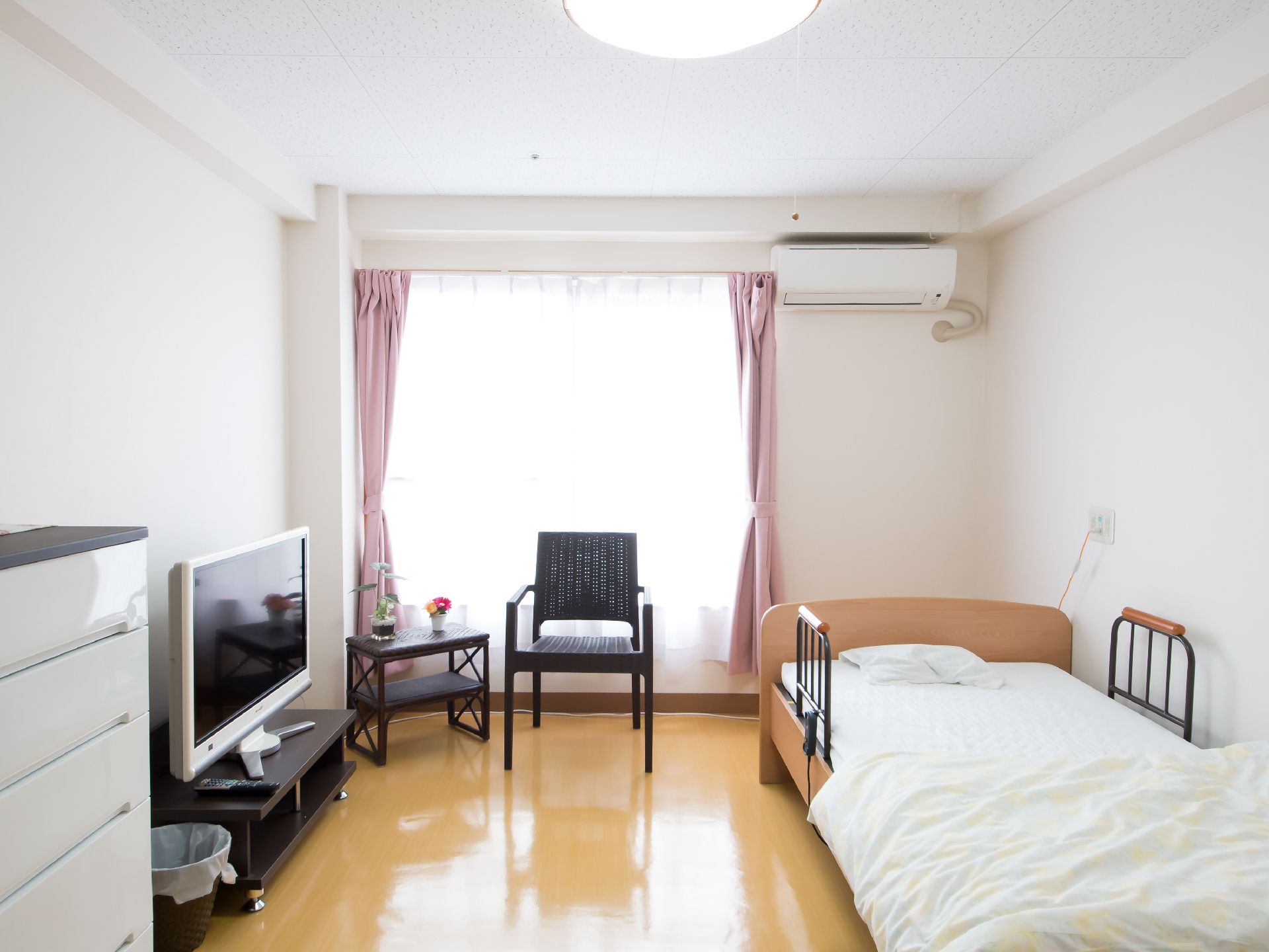 エアコンが設備され、生活家具が配置された明るい室内