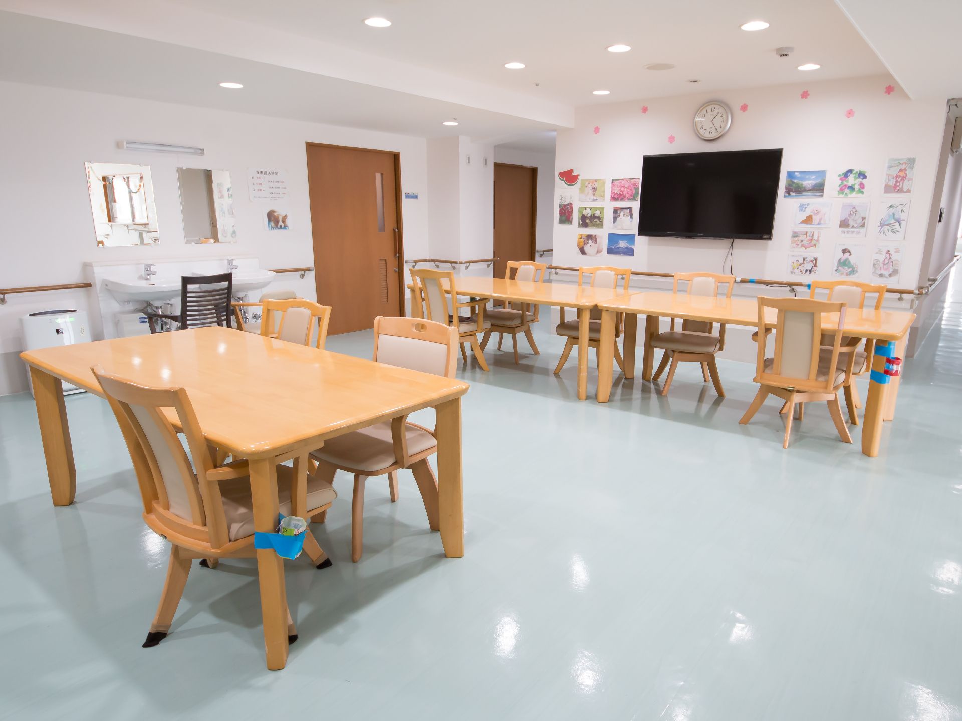 沢山のイラストが掲示され、大きなテレビが壁に取り付けられた食堂