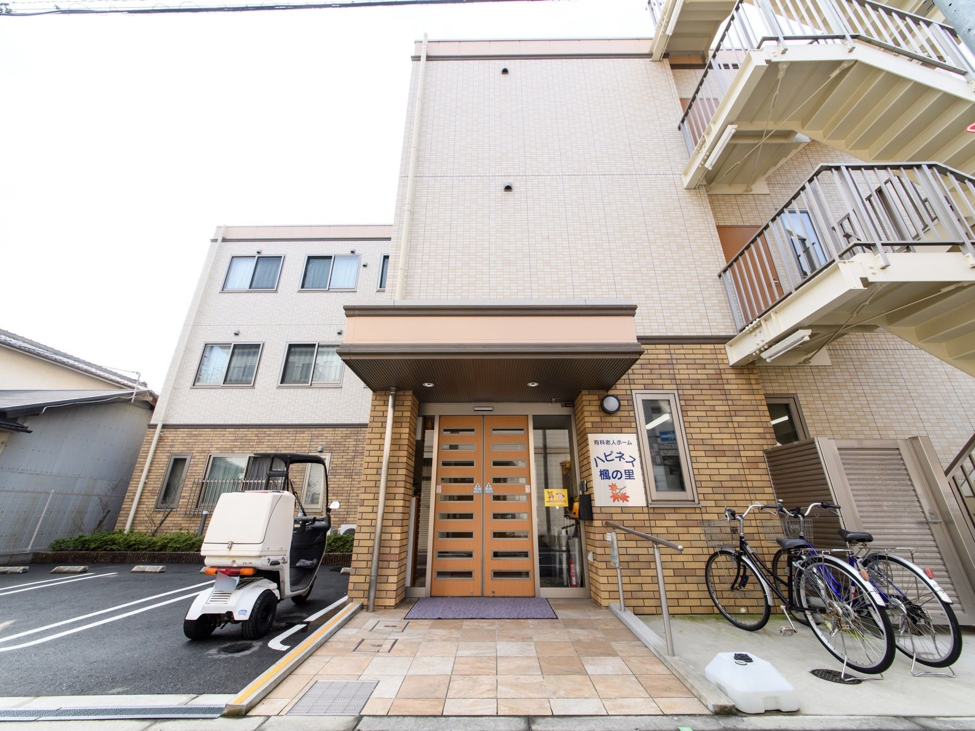 施設は３階建てで、１階に入口がある。入口前には手すりがあり、ドアは自動ドアなので、足の不自由な方でも利用しやすい。