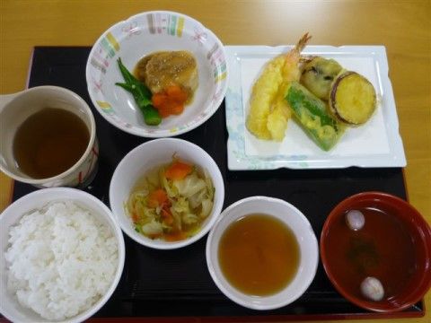トレーの上に並べられた天ぷらや煮物、お吸い物などの料理