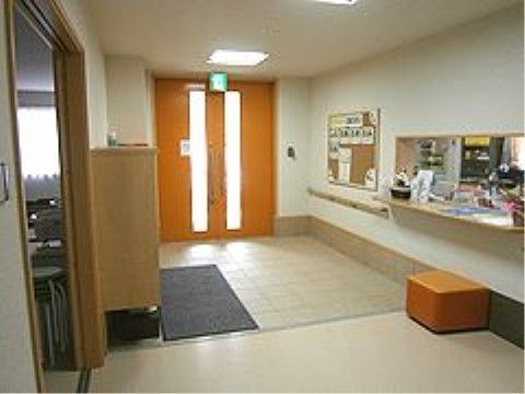 玄関に設置されている受付カウンターには、クッション性のある椅子を配備している。履物の脱ぎ履きの際に便利で安全である。