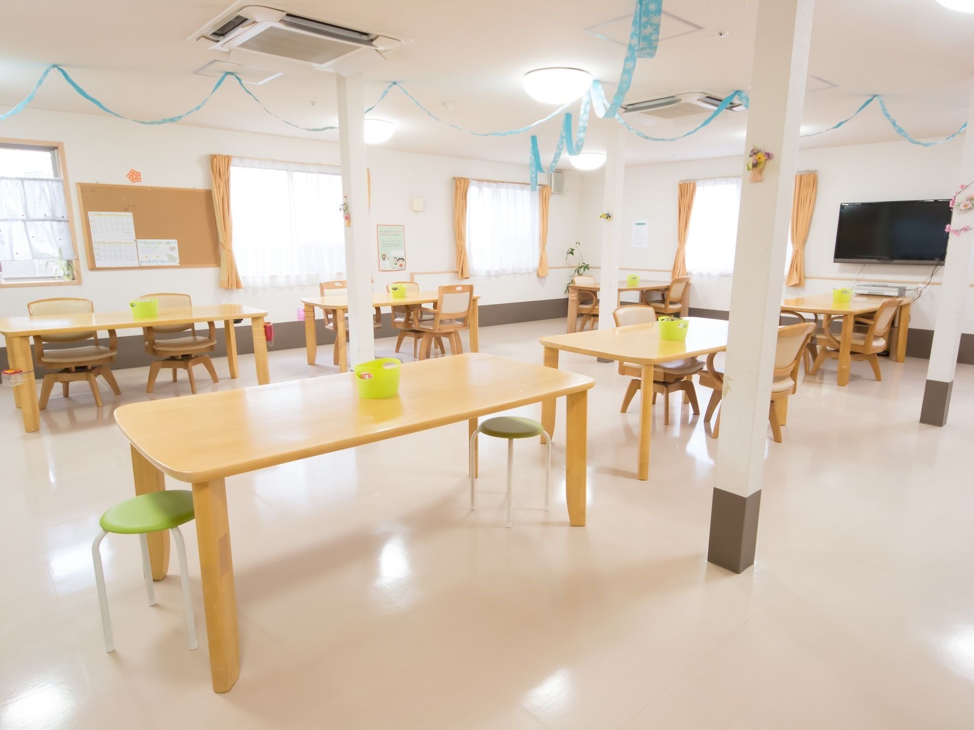 長方形のテーブルは角が丸く、怪我のしにくい形である。用意されている椅子は回転するため、座りやすく立ちやすい。