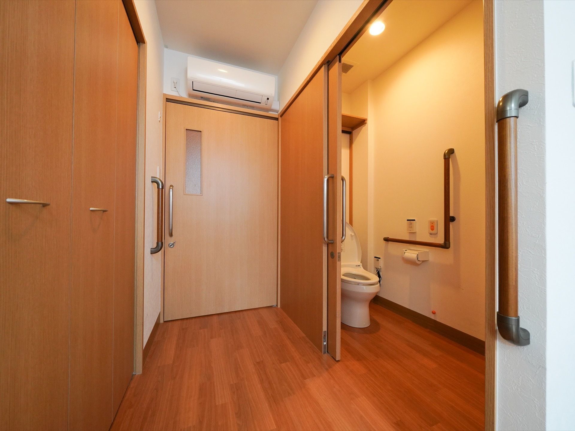 居室のトイレはドアが引き戸で段差がない。個室内には洋式で、壁には手すりや緊急時呼び出しブザーが備わっている。