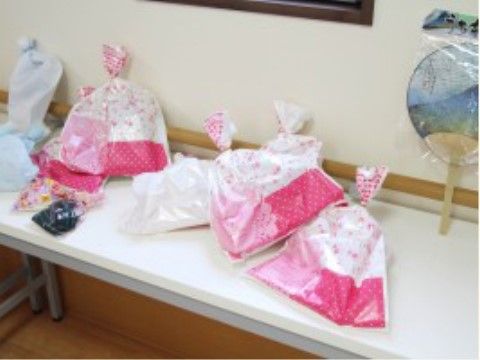 机の上に並べられ、上部を結ばれた白とピンクのラッピングバッグ