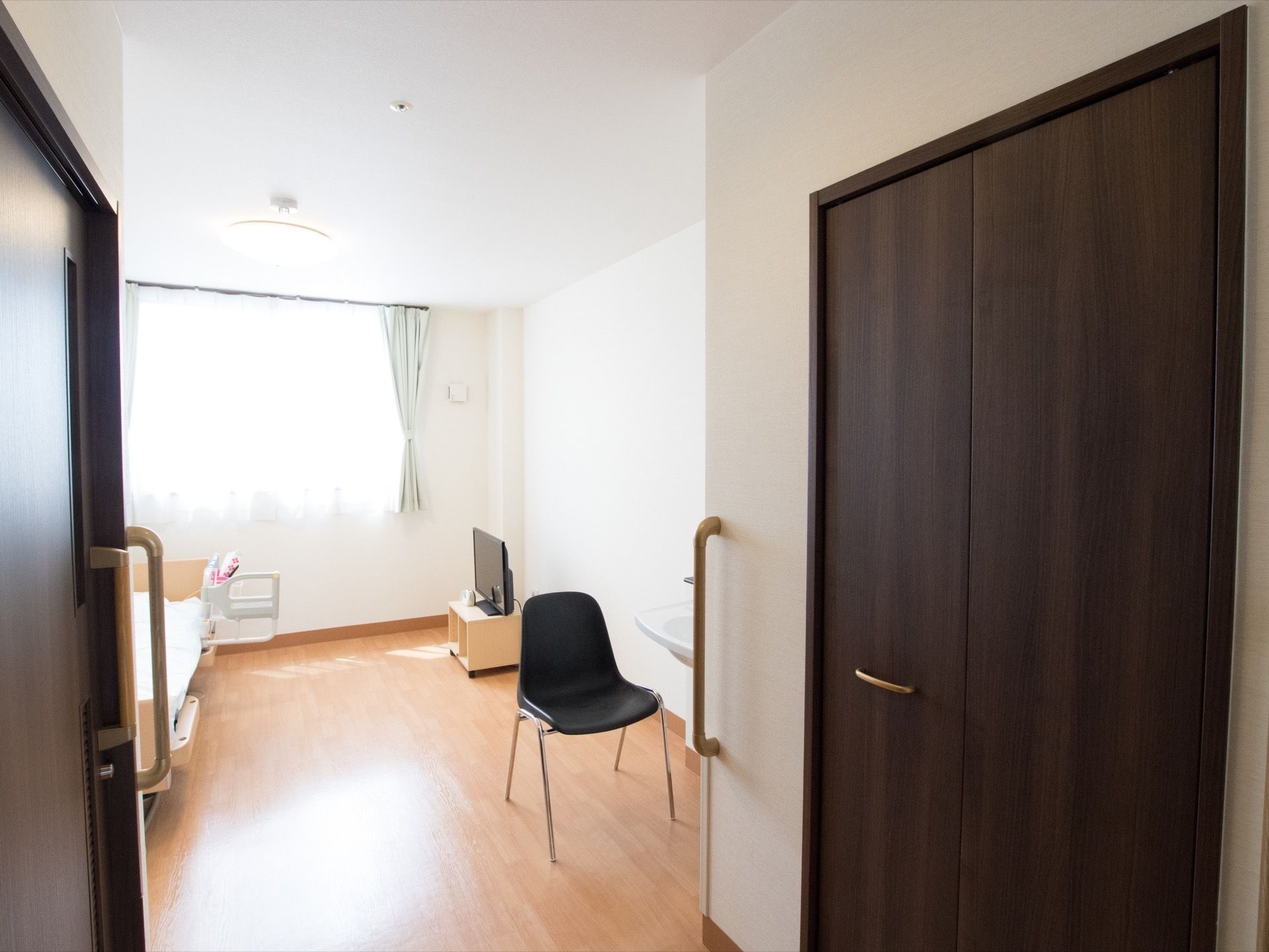 広々とした窓から、外の光が居室に降り注いでいる。白い壁にダーク系の建具でコーディネートされ、おしゃれな雰囲気がただよう。