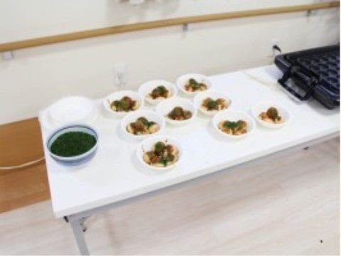 白い長机に、たこ焼き器とたこ焼きが並べられている。季節ごとの行事食やイベント食などが、年間を通じて用意されている。
