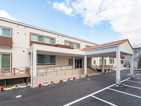 ２階建ての白を基調とした建物は玄関に雨よけ屋根があり、車で来館いただいた来訪者様が雨に濡れることなく館内にご移動いただける。