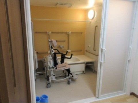 浴槽の他にシャワー機能付きや介護仕様の椅子を設けて、お体の調子に合わせた使用に配慮している。手すりも連続して配置されて安心して利用できる。