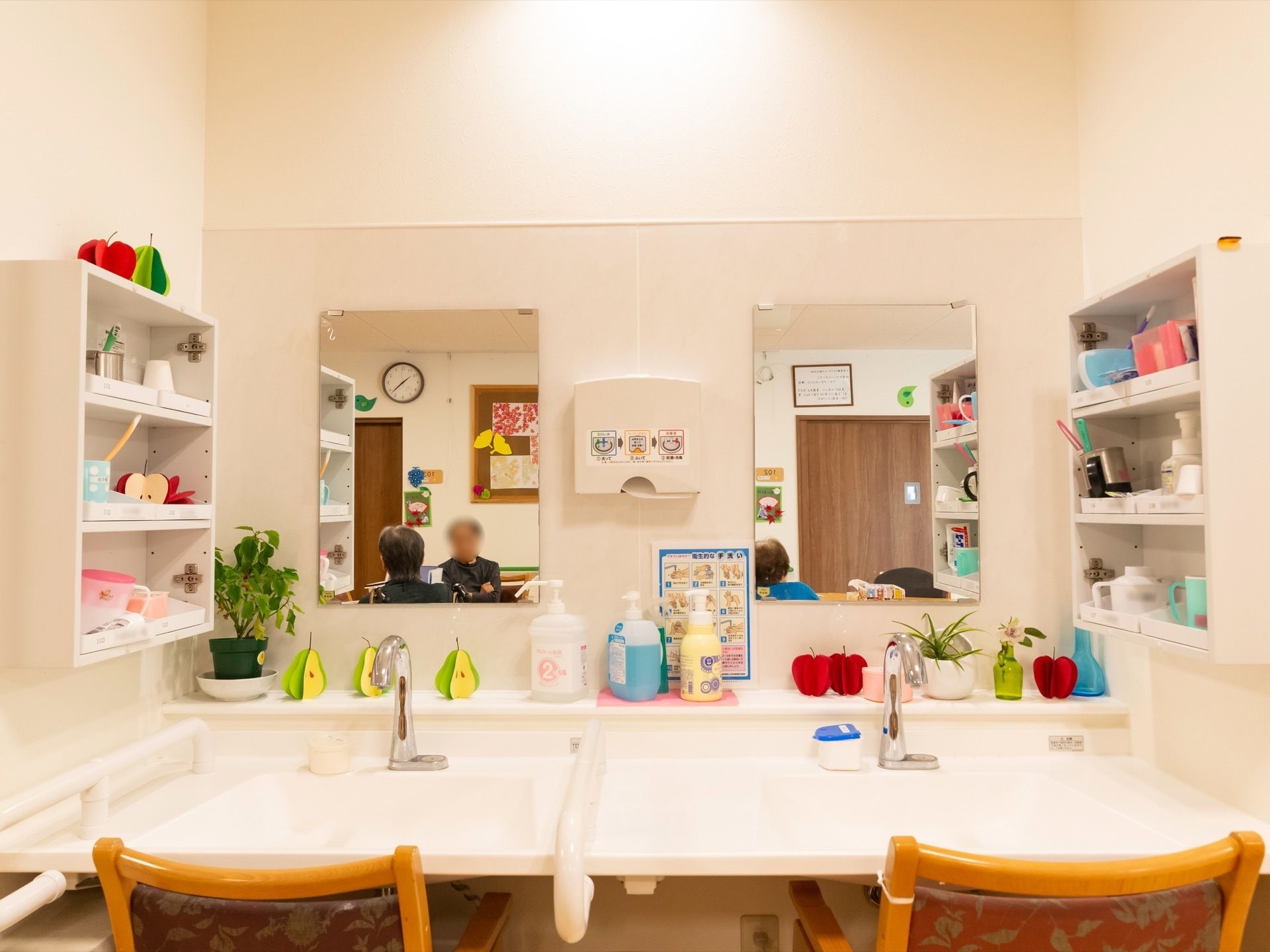 ２つの洗面スペースがある洗面台で、前面にはそれぞれに鏡が設置されている。ハンドソープや消毒等の衛生用品も並べられている。