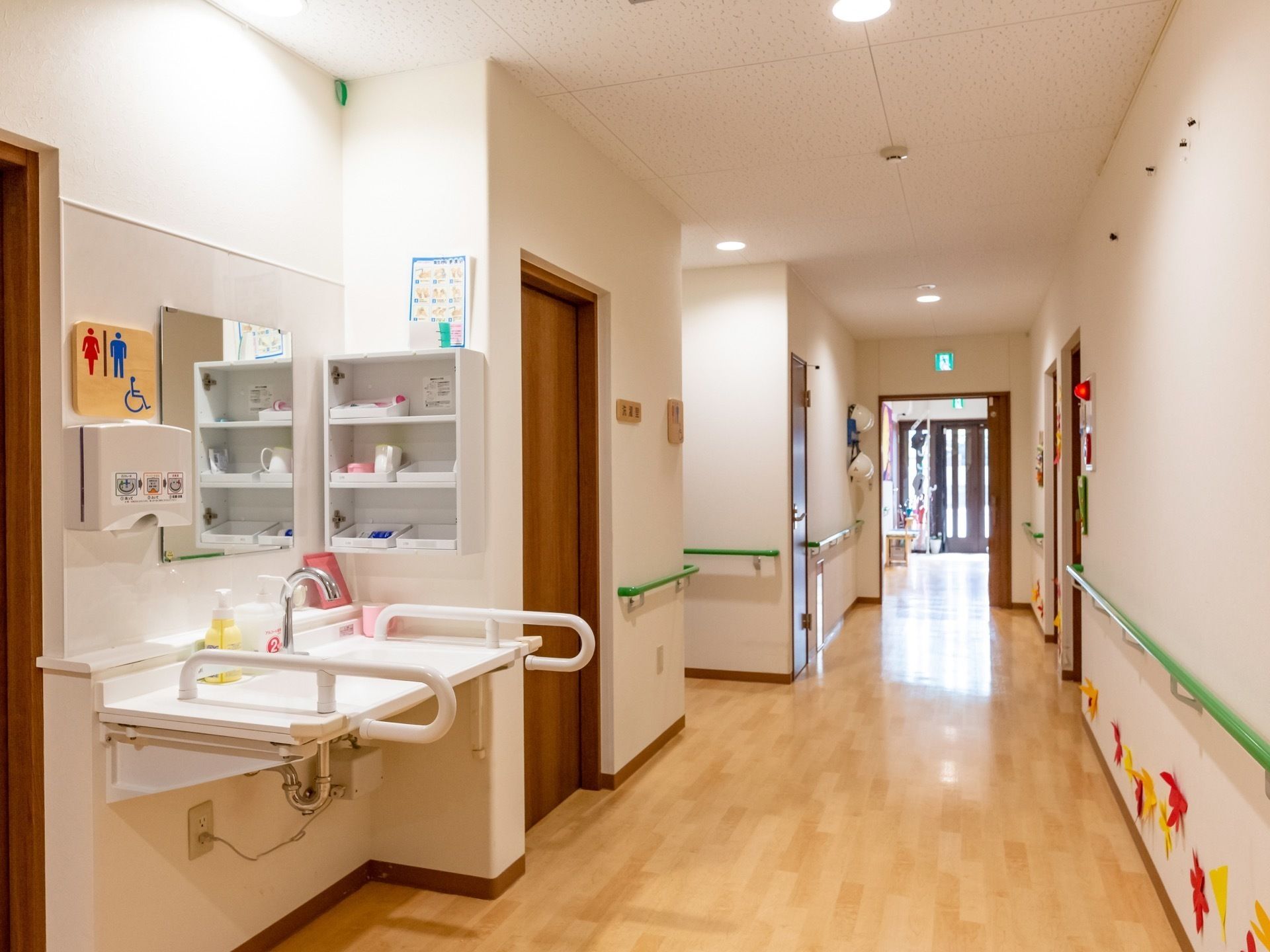 紙で作られた紅葉の葉が飾られ、緑の手すりが壁沿いに巡らされた通路