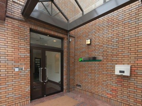 入口の横にはさりげなく施設名が掲げられている。バリアフリー構造となっていて、外側から建物内への移動がスムーズである。
