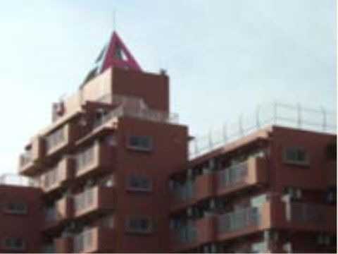 三角形の特徴的なアクセントのある、オレンジ色の外壁の建物
