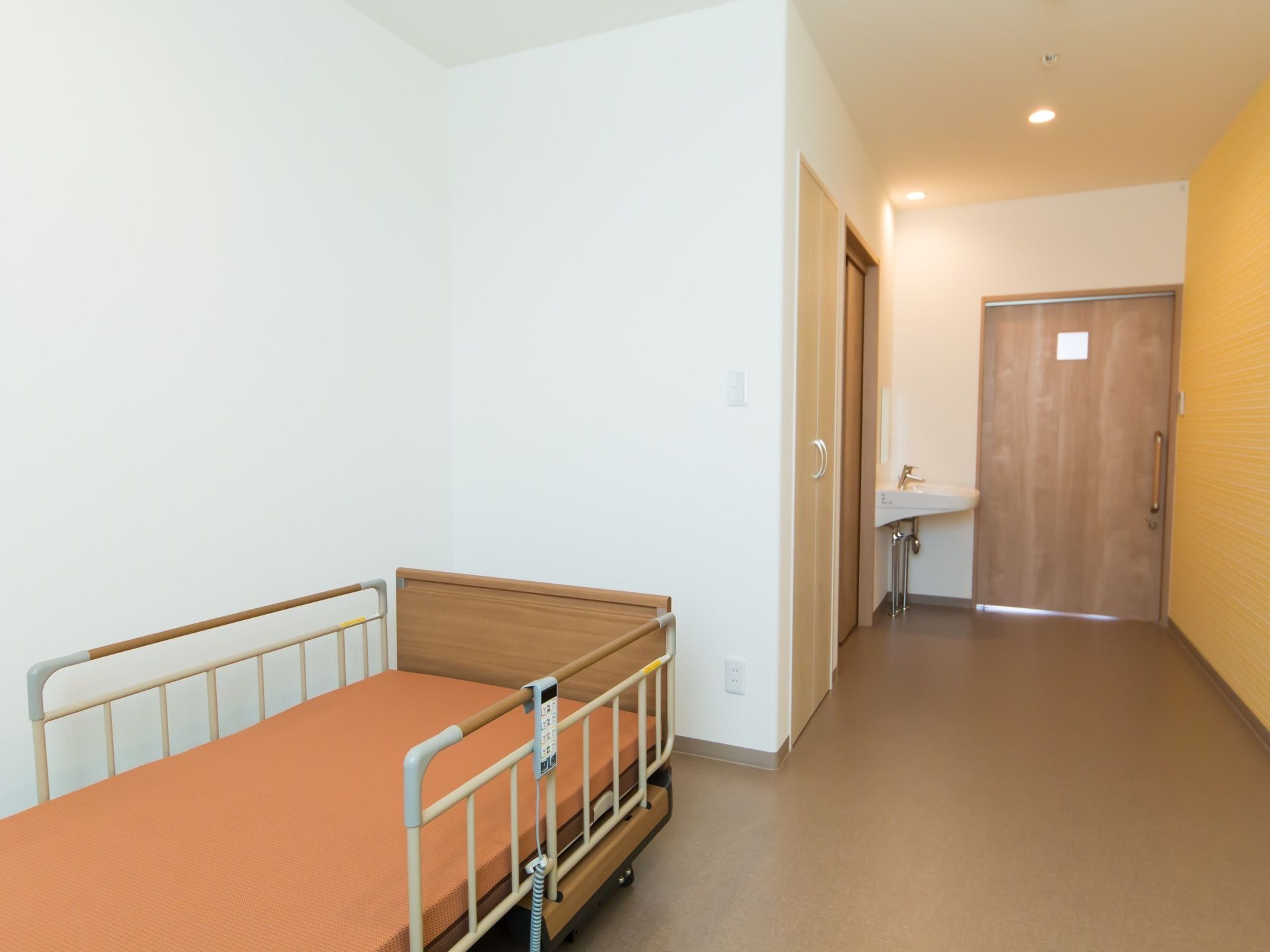 温かみのある木製のドアは入居者様に安らぎを与えてくれる。居室にはベッドが備え付けられていて、リクライニング機能がある。