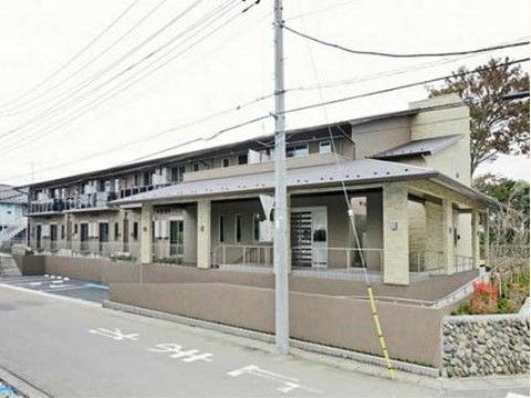 道路に面しており、車でのアクセスも便利である。2階建てのベージュを基調とした建物で、入口付近にはスロープと階段がある。