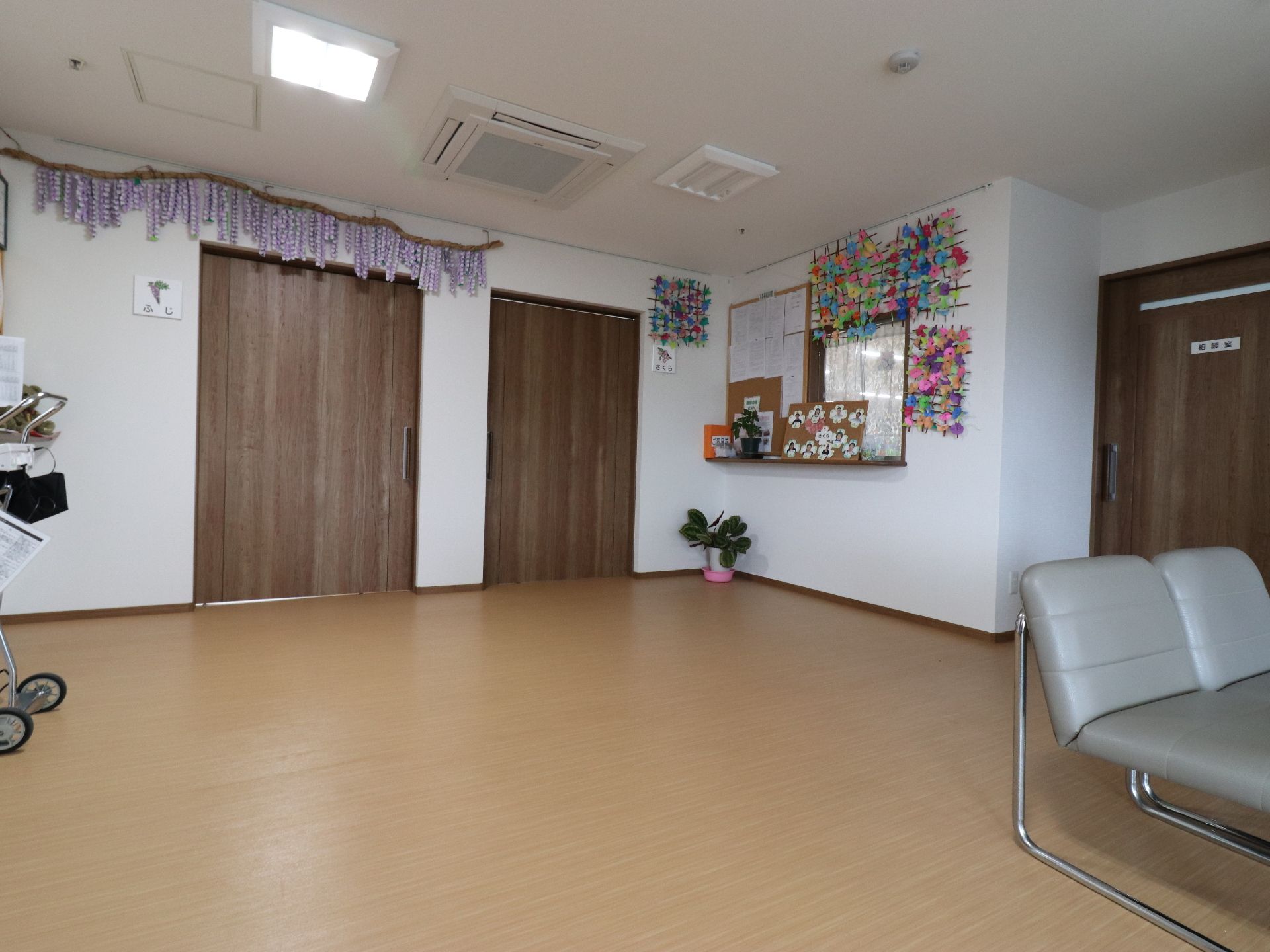 角には観葉植物がある。壁にはたくさんの折り紙が飾られている。お知らせなどの紙などもこちらに貼られている。