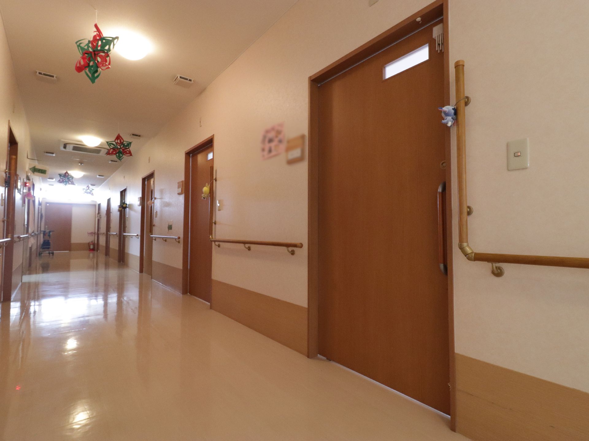 クリーム色と茶色が使われた廊下である。居室の入り口には、それぞれマスコットを飾っている。扉の隣には表札がついている。