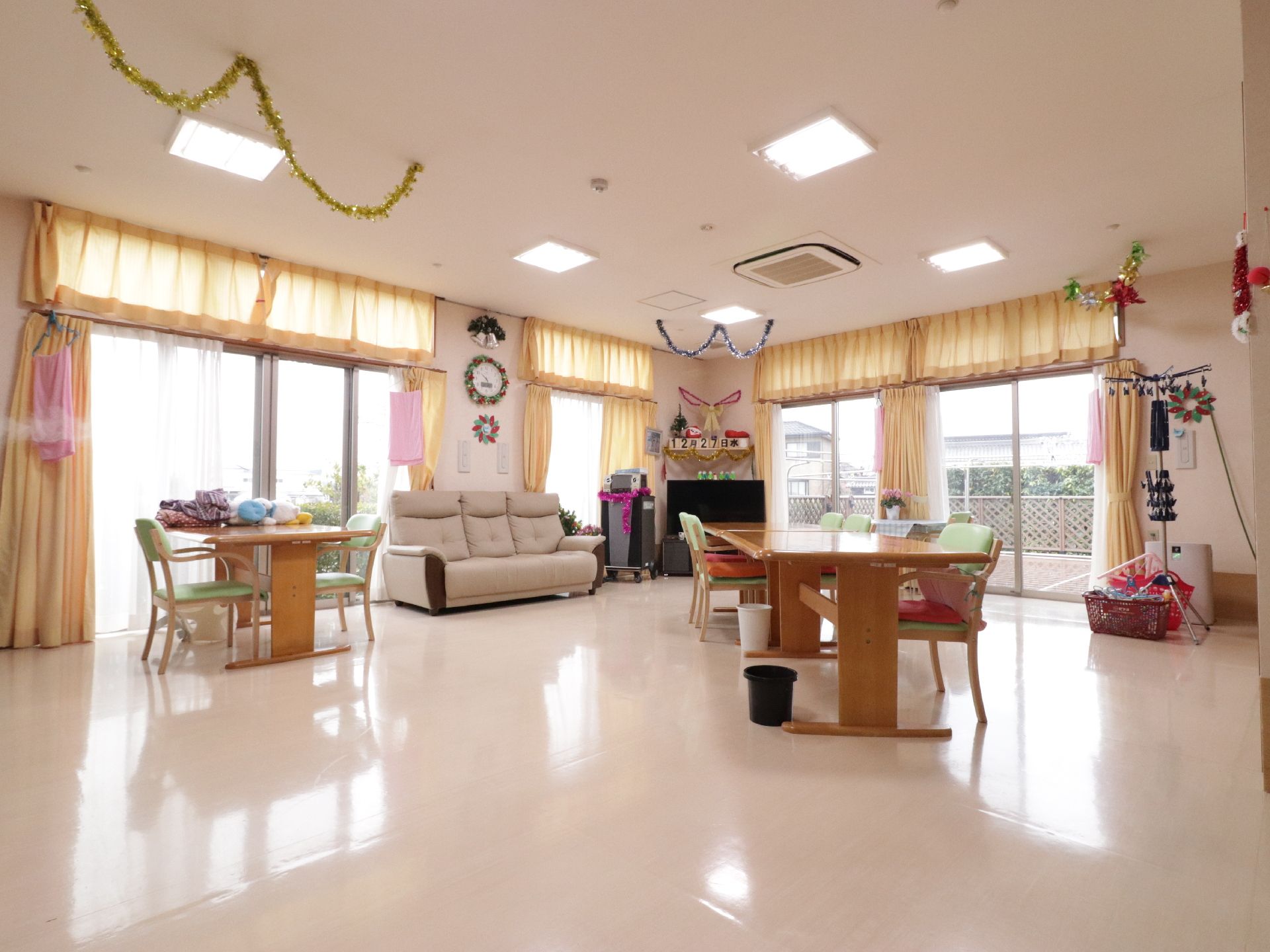 リビングは広々としている。壁側にはテレビやソファーが置かれている。部屋の中央には茶色いテーブルと椅子が並べられている。