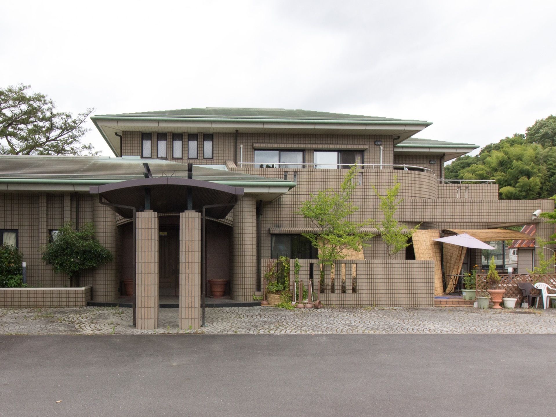 施設は大きな一軒家風の２階建ての建物である。建物前に駐車スペースが設けられている。エントランスには、屋根付きの車寄せがある。