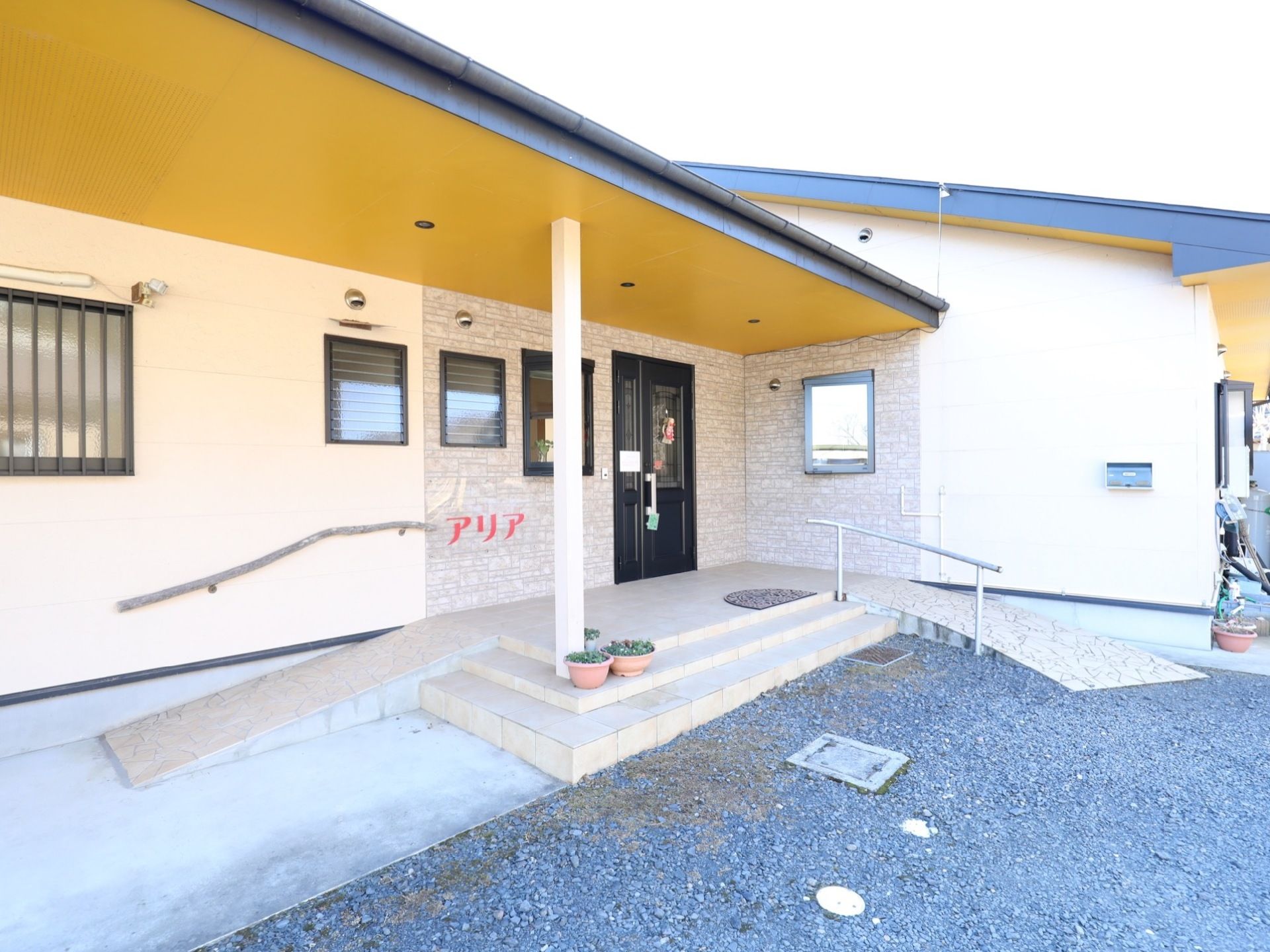 グループホームの建物は平屋建てで、ブラウン色の外壁となっている。壁には施設名が書かれた看板があり、郵便受けを設置している。