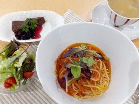 トマトソースのパスタ、サラダ、デザート、スープなどが置かれた食卓
