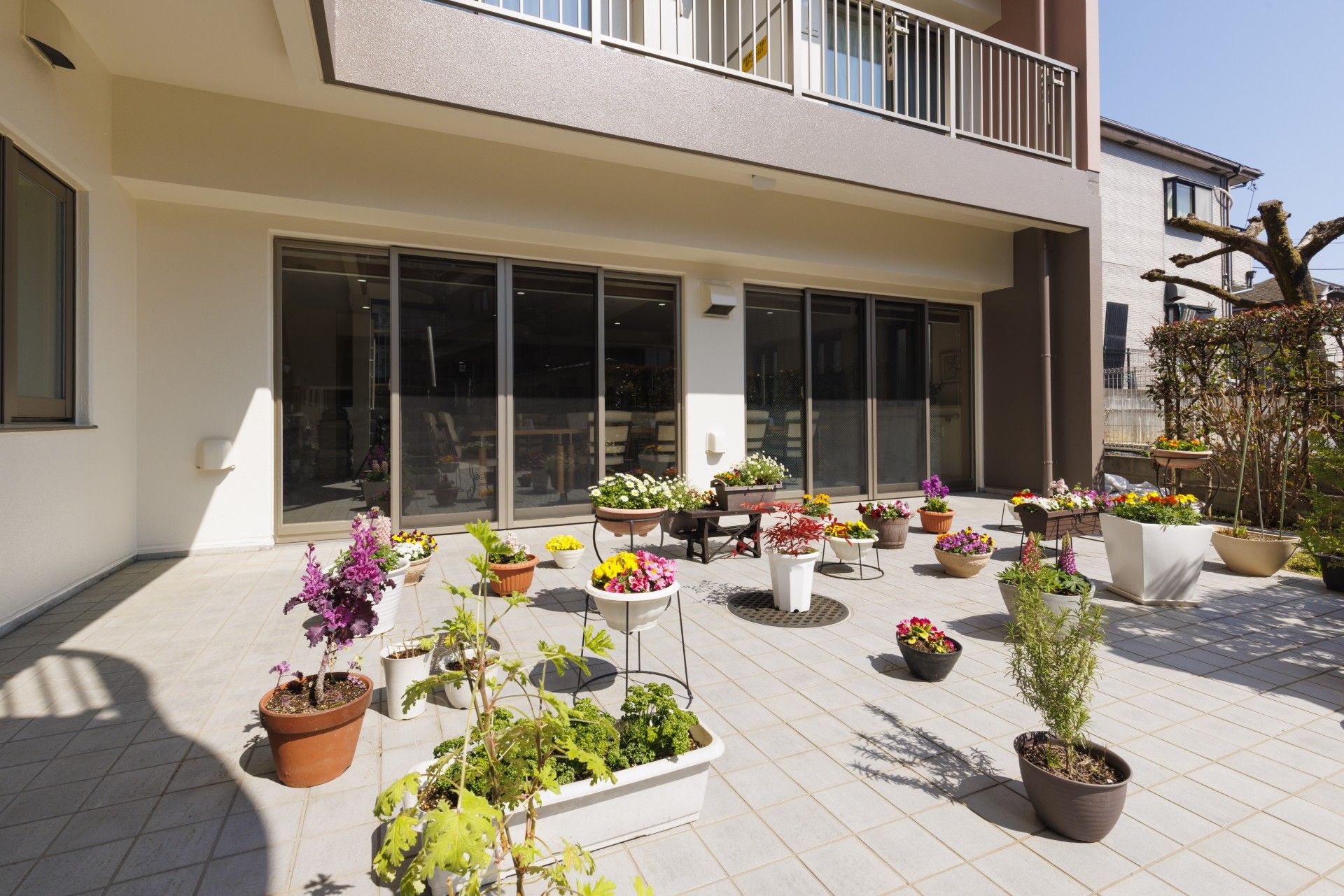 テラスには円形のテーブルが２台設置されていて、それぞれに肘掛け付きの黒い椅子が３脚セットされている。