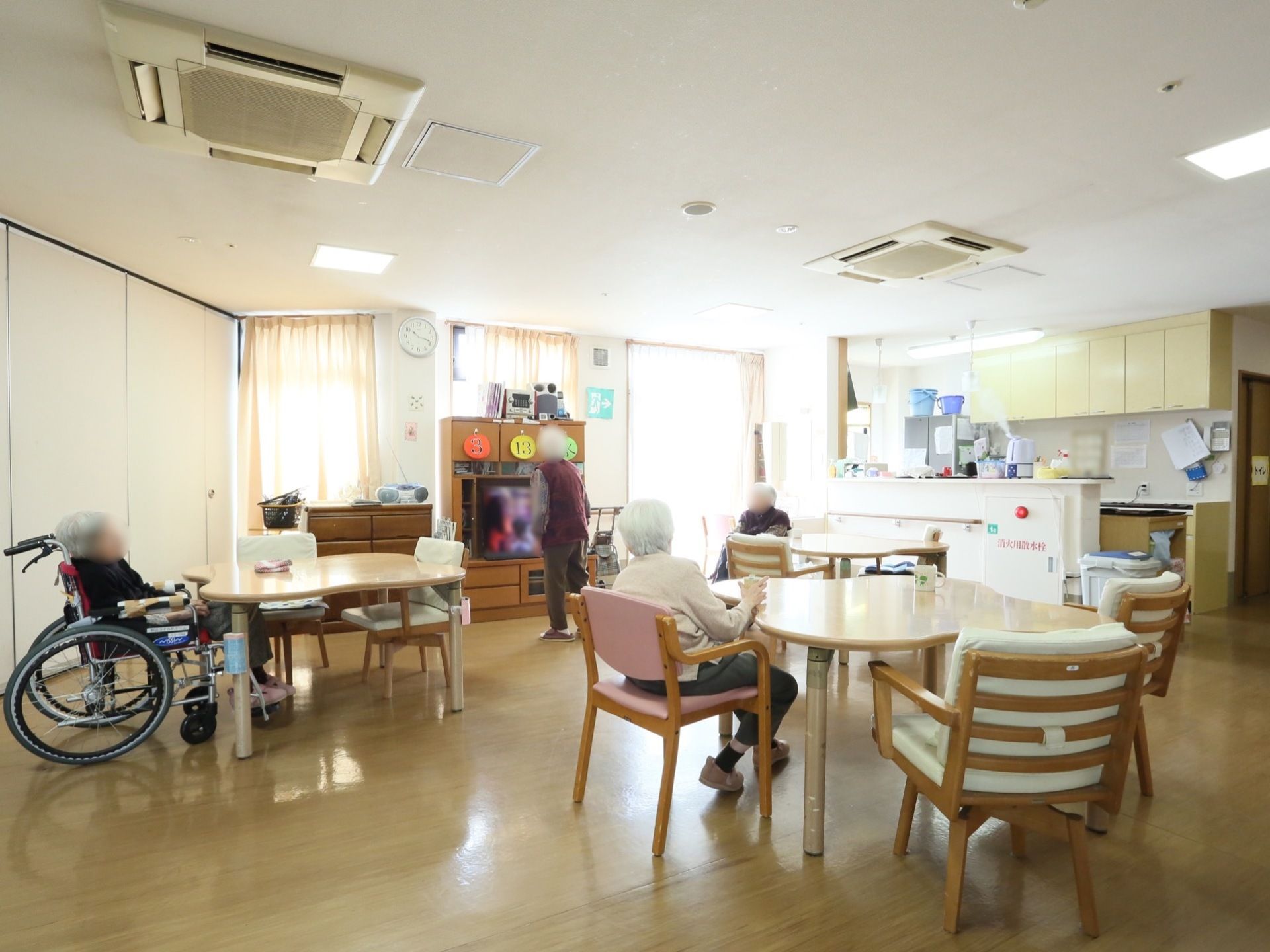 リビングに併設してキッチンがあり、シンクがある。キッチンには、冷蔵庫や消毒液等が置いてあり、リビングから見えている。