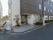 焦げ茶色と白色の外壁の建物で、入り口はガラス張りの扉である。周囲に木などの植木が植えられている。入り口前には施設名が表示されている。