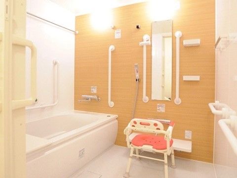 浴槽の周囲には手すりが十分に設置され、安全に入浴することができる。シャワー設備と専用のチェアが設けられている。