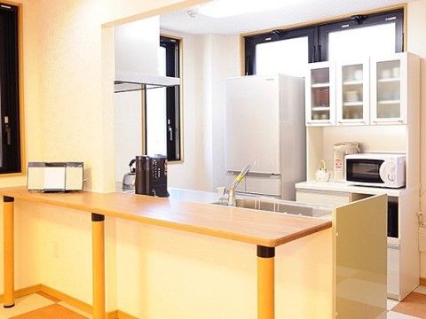 カウンター付きのキッチンである。IHコンロの他、冷蔵庫、電子レンジ、食器などを用意しているので、いつでも料理ができる。
