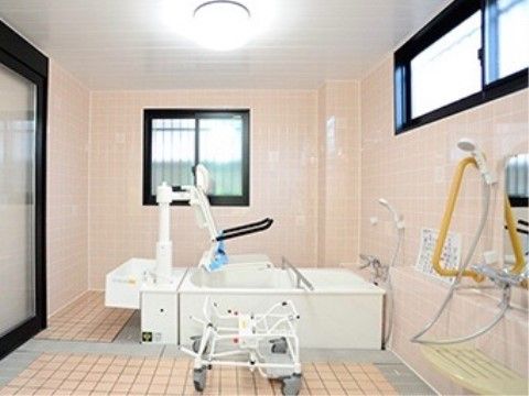 ベージュ色を基調とした、窓のある明るい浴室に、介護浴槽が設置されている。座ったままでも入浴することができる。