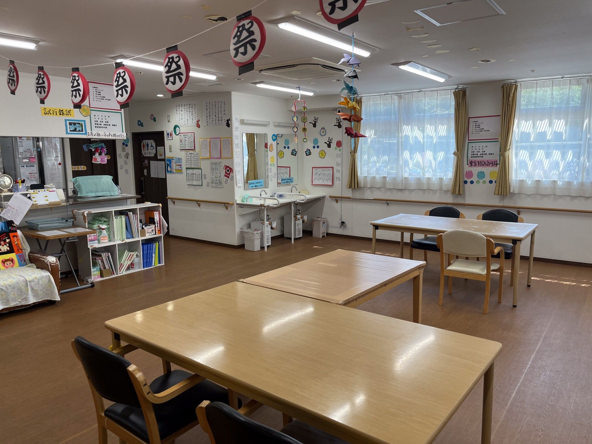 共有スペースで、二人並んで包丁で白菜を切る入居者様