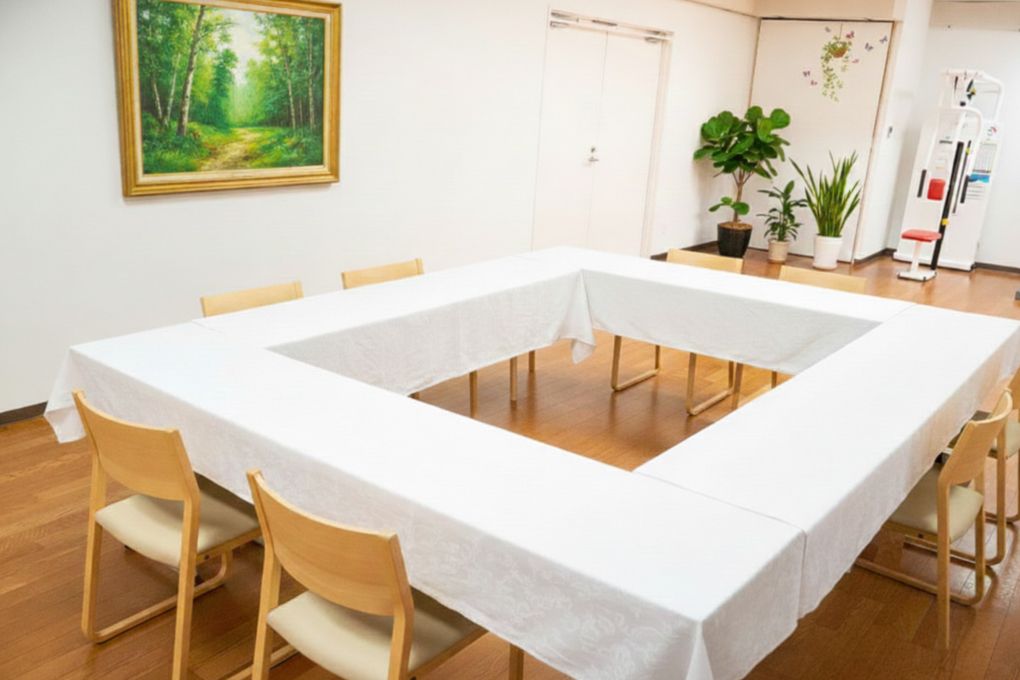 食堂には複数の茶色いテーブルと椅子が並べられている。壁にはカレンダーがかけられている。テレビ1台が完備されている。