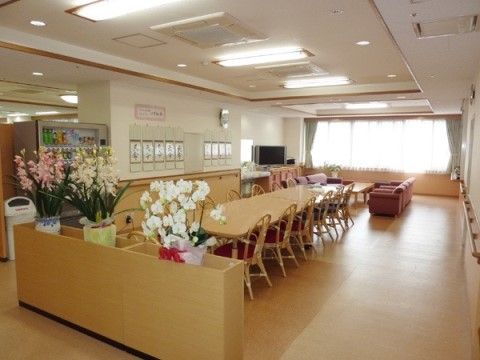 中央にはテーブルと椅子が並べられている。奥にはソファとテレビが置かれている。自動販売機が設けられている。