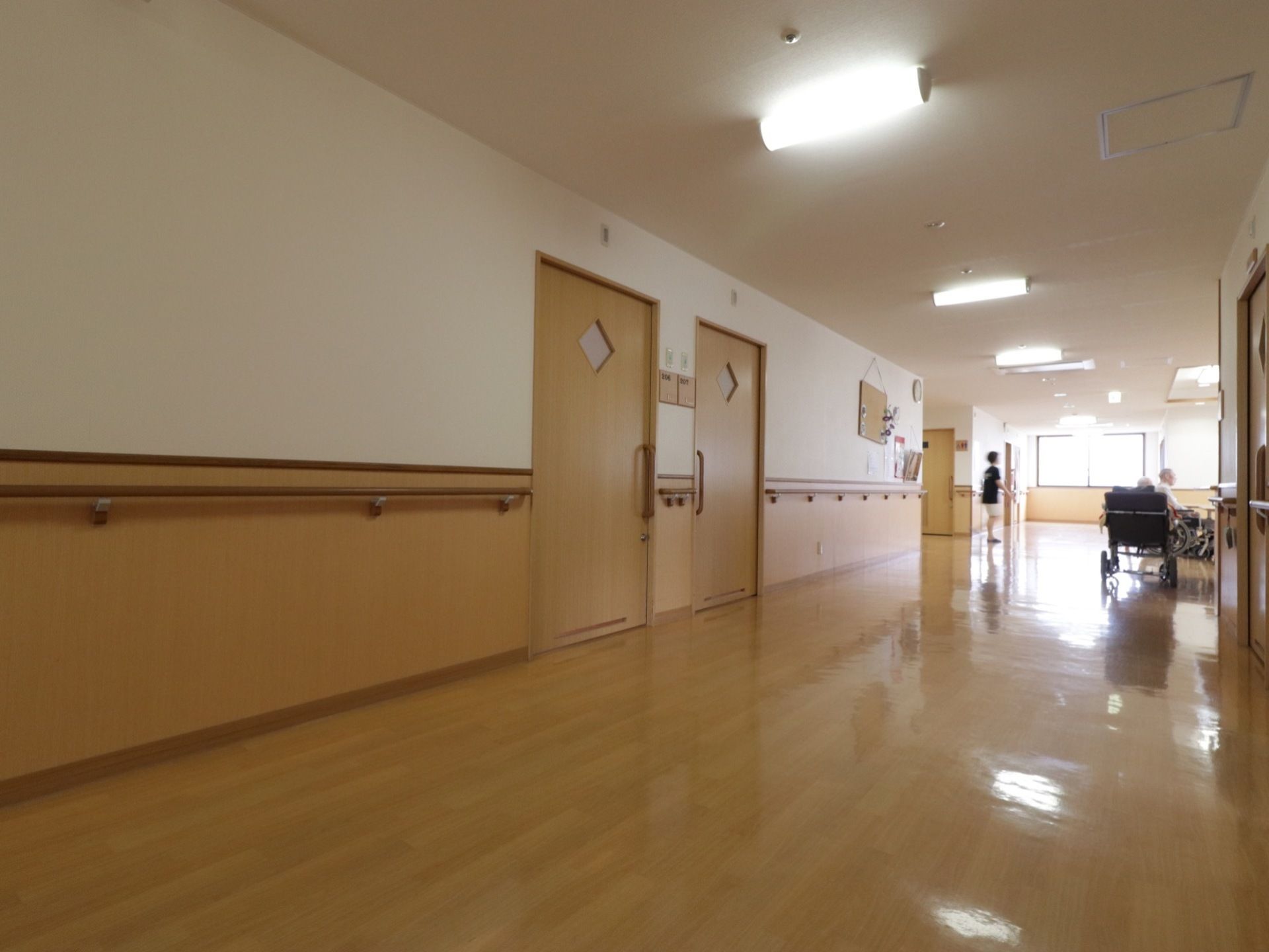 ベージュ色の引き戸が、左右対称に二つ並んで設置されている。その右横には掲示板が掛けてあり、アサガオの花が飾ってある。