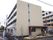 四階建ての建物。一階は共有の施設で、二階から四階までがご利用者の居住スペースとなとなっている。外には自動販売機がある。