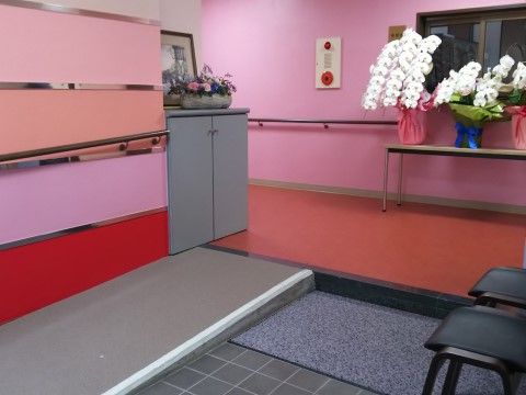 「らいふつくば花畑 別館」の玄関。赤とピンク色の、可愛いカラーリングの玄関。