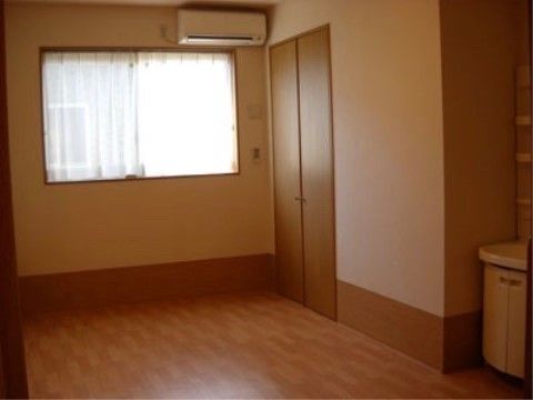 窓の上にエアコンがあり、双方がある隣の壁にはクローゼットが作り付けられている。こぢんまりとした洗面台も取り付けられている。