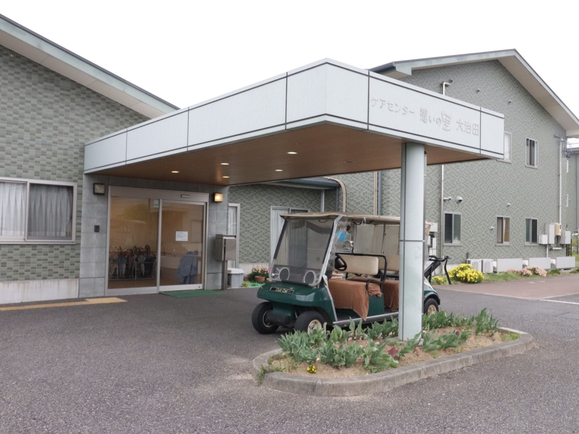玄関の前に移動用の乗り物が置かれている。施設は北と南の棟に分かれているので、安全に移動することができる。