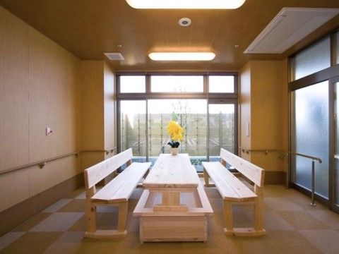 大きな窓のついた、壁際に手すりのある部屋に設けられた足湯の設備