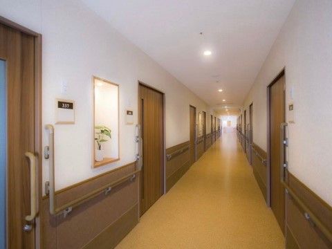床面はライトベージュ色で、段差がない。居室のドアは引き戸になっている。両壁面には手すりが付いている。