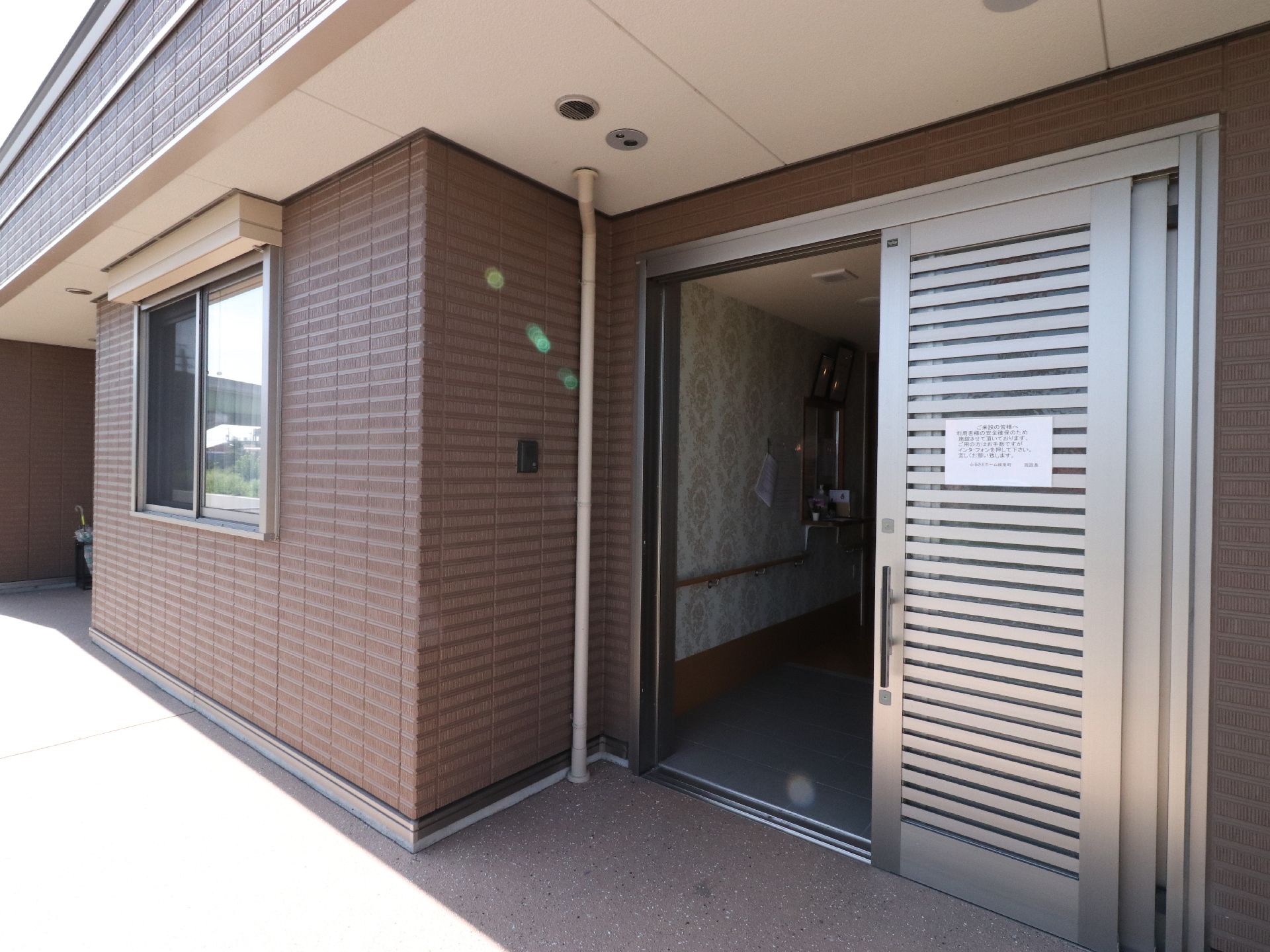 施設には、玄関が2箇所ある。玄関と玄関の間に事務所があり、それぞれ受付がある。右側の玄関には、左の壁にインターフォンがある。