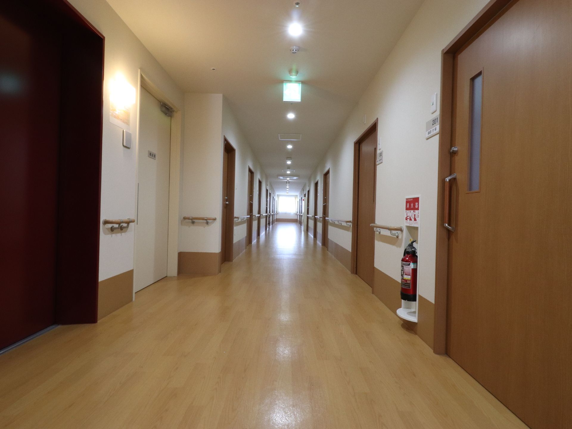 居室と居室を結んでいる廊下は、まっすぐ伸びている。居室のドア横には、部屋番号と氏名が記載されている。