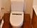 居室内のトイレ。壁には手すりが設置されている。洗面台もトイレ内に設けられており、一般的なマンションに近い設備である。