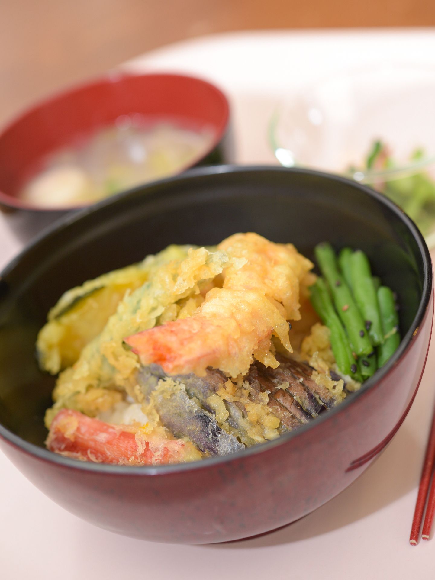 なすび、インゲンなど彩もきれいな緑黄色野菜と中心にした天ぷらのどんぶりが入居者のメニューの一例として、カメラに納まっている。