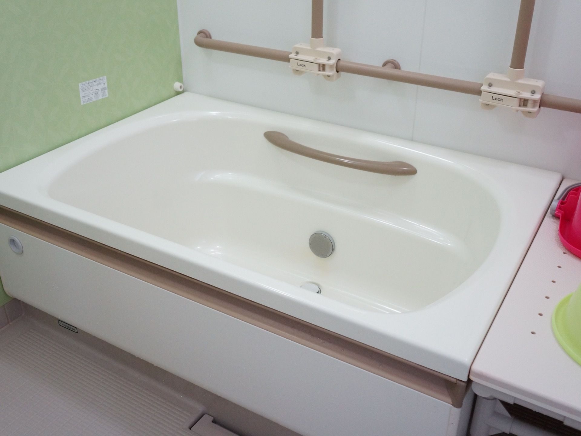 浴室では、壁やシンプルなデザインのユニットバスに手すりが設置されている。入浴補助器具も配備され、安全対策がとれている。