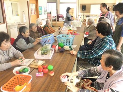 沢山の入居者様が長テーブルを囲んで行う施設のアクティビティ