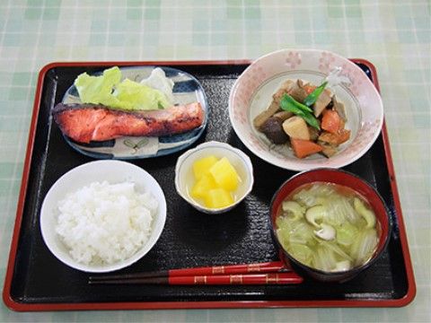 様々な食材が彩りよく使われた料理がお盆の上に並べられた、施設の食事