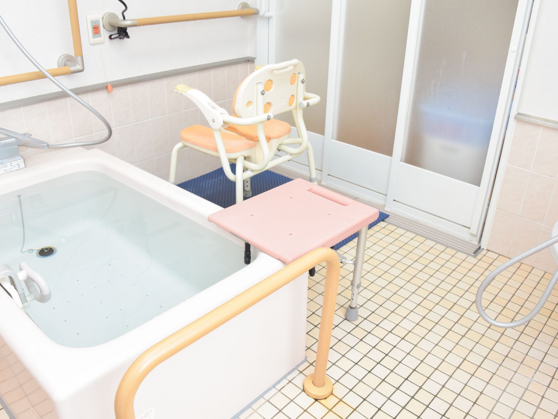 湯船に体を入れるときに段差がなくなるように補助椅子、手すりなどが設置されている。滑り止め防止のマットが置いてある。