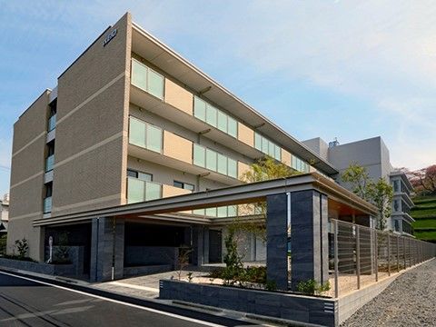 明るい色合いで、入居者様の居室にも繋がっているベランダが並ぶ施設の外観